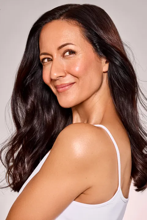 Kati Martin – Beauty-Porträt im weißen Top vor rosafarbenem Hintergrund